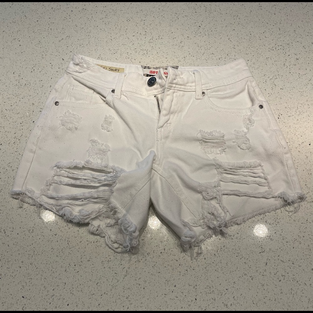 White jean shorts distressed and frayed edge details.